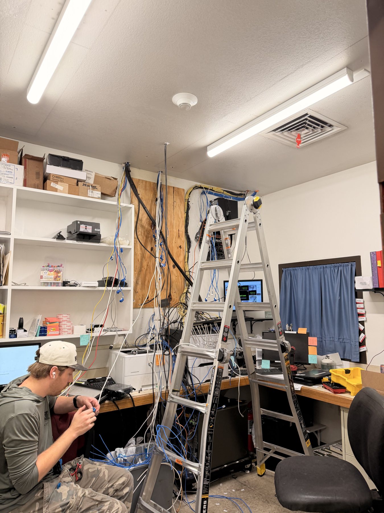 Technician terminating network cabling in an active commercial workspace